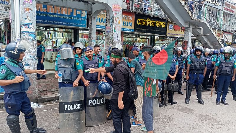 পুলিশ সদস্যদের বিস্কুট দিচ্ছেন আন্দোলনকারীরা। রাজধানীর সায়েন্স ল্যাব মোড়ে, আজ শনিবার দুপুর সাড়ে ১২টায়